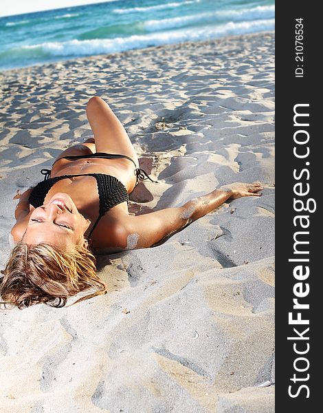 Young woman in black bikini on beach. Young woman in black bikini on beach
