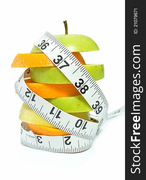 Tape measure wrapped around orange and apple slices. Tape measure wrapped around orange and apple slices