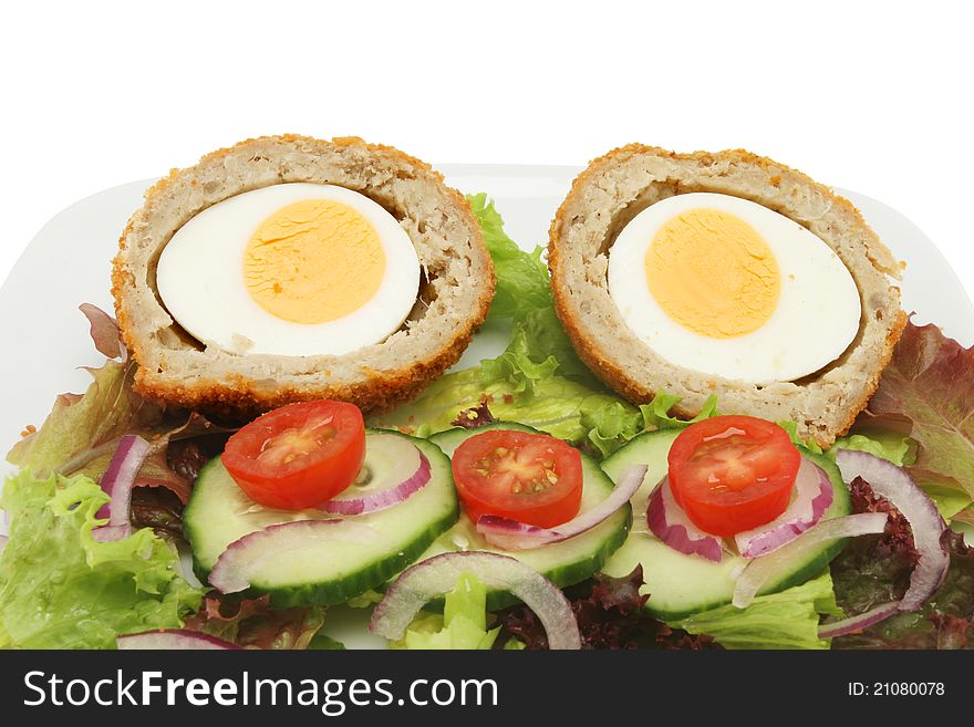 Closeup of two half scotch eggs and salad. Closeup of two half scotch eggs and salad