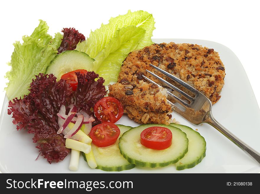 Closeup of a fish cake and salad with a fork on a plate. Closeup of a fish cake and salad with a fork on a plate