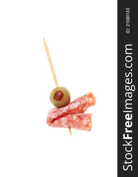 Olive and salami on a cocktail stick isolated against white