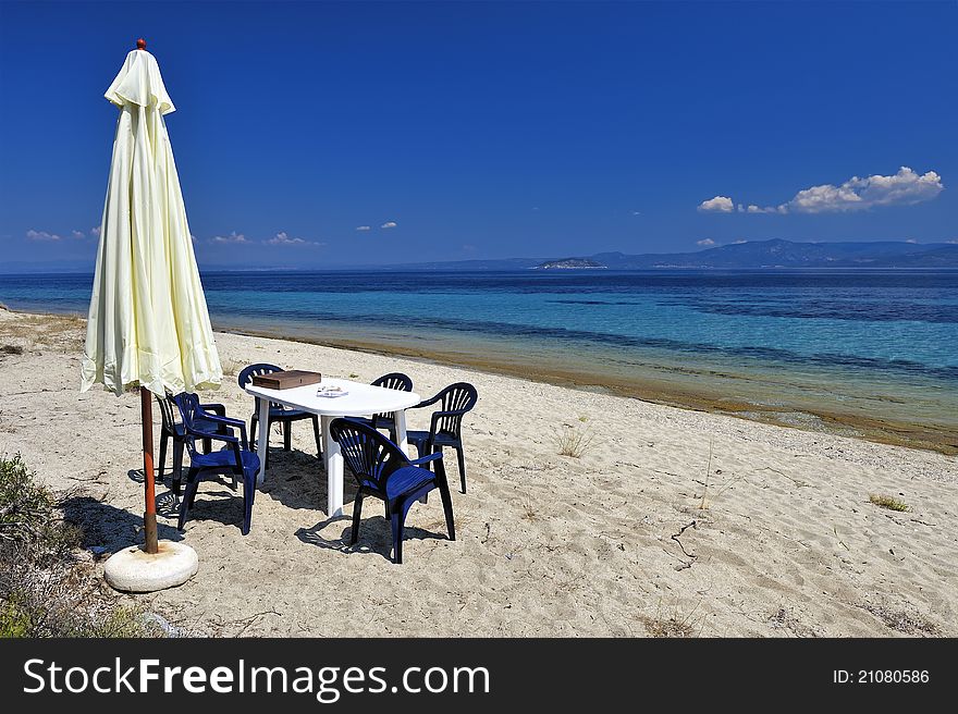 Umbrella,table and six stools on the beach