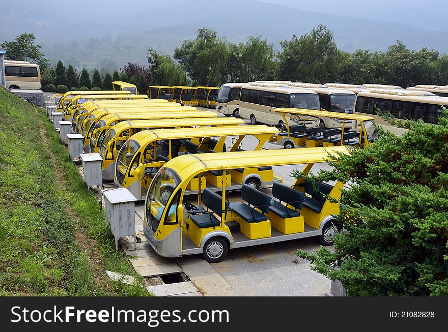 Parking place with electrical yellow buses for touristic transport charging the battery. Parking place with electrical yellow buses for touristic transport charging the battery