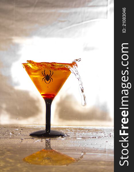 Martini glass with spider on it with defused backgrouind. Martini glass with spider on it with defused backgrouind