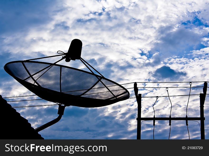 Satellite dish and electricity post in morning sky