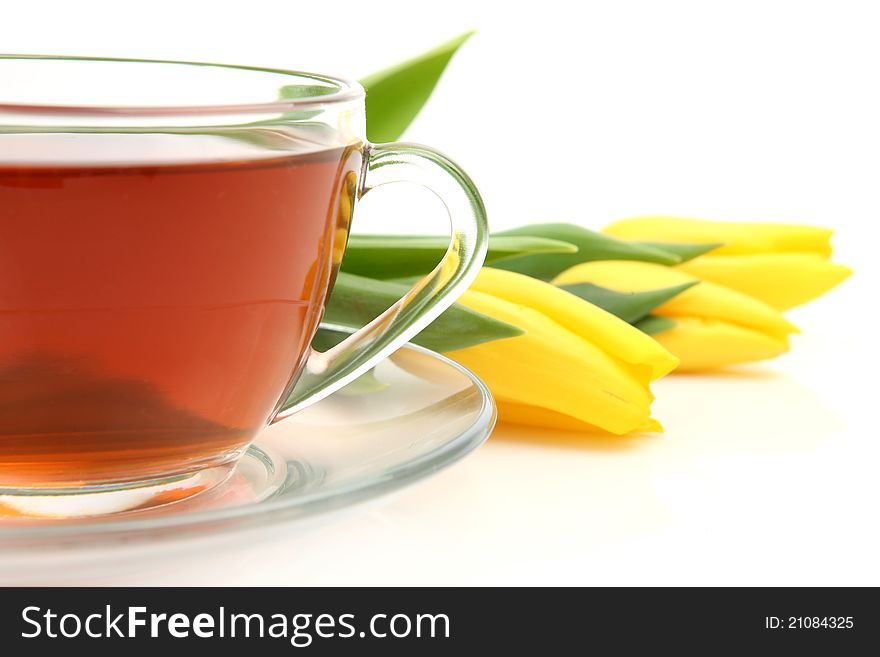 Tea and yellow tulips on a white background