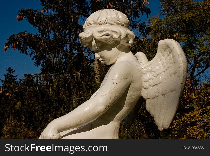 White marble statue of an angel with wings on his back