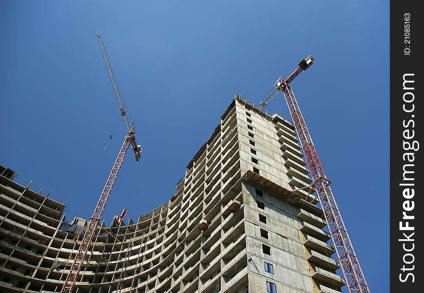 Building crane at the background of building under construction