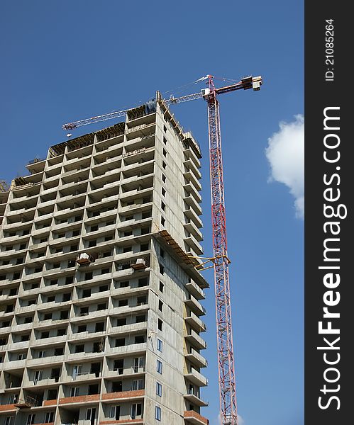 Building crane at the background of building under construction