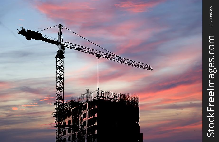 Building crane at the background of building under construction