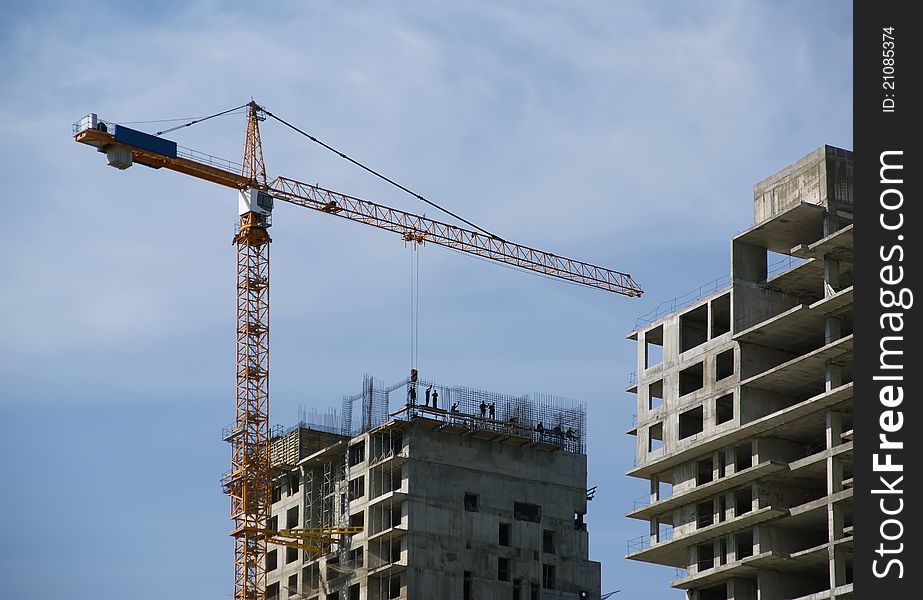 Building crane at the background of building under construction