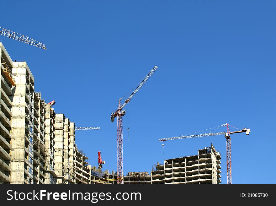 Building crane at the background of building under construction