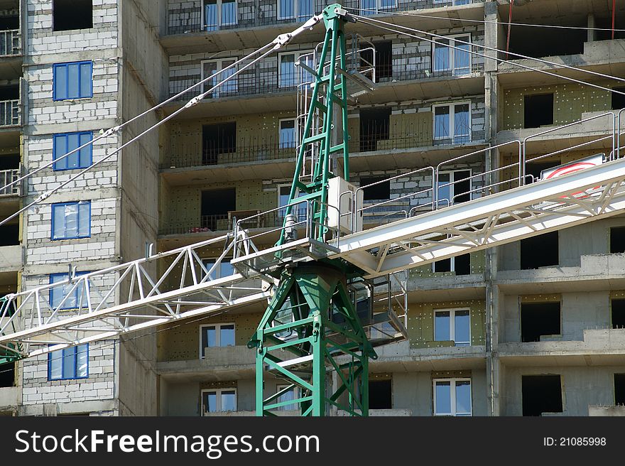 Building crane at the background of building under construction