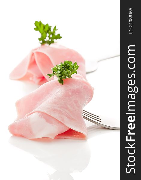 Photo of delicious ham sliced wrapped on fork over white background. Photo of delicious ham sliced wrapped on fork over white background