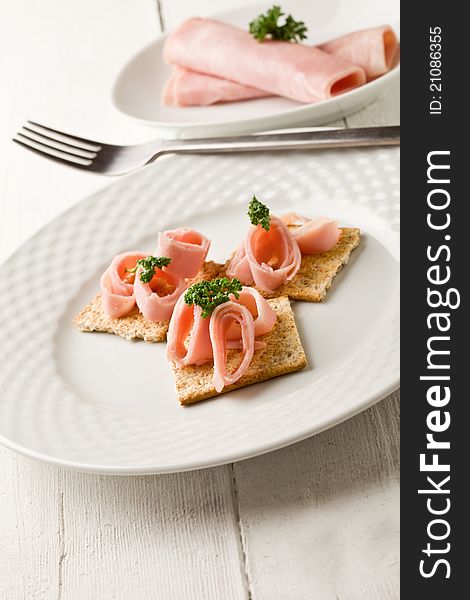 Crackers canapes with ham and parsley