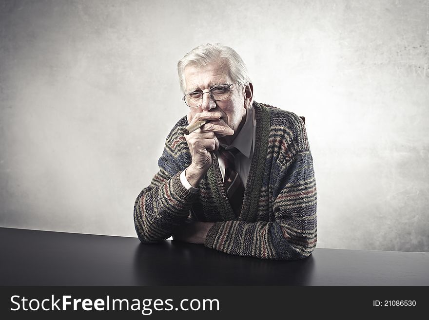 Portrait of a senior man smoking a cigar. Portrait of a senior man smoking a cigar