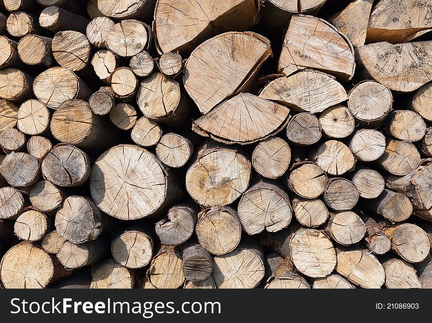 Dry chopped firewood logs stacked up on top of each other in a pile