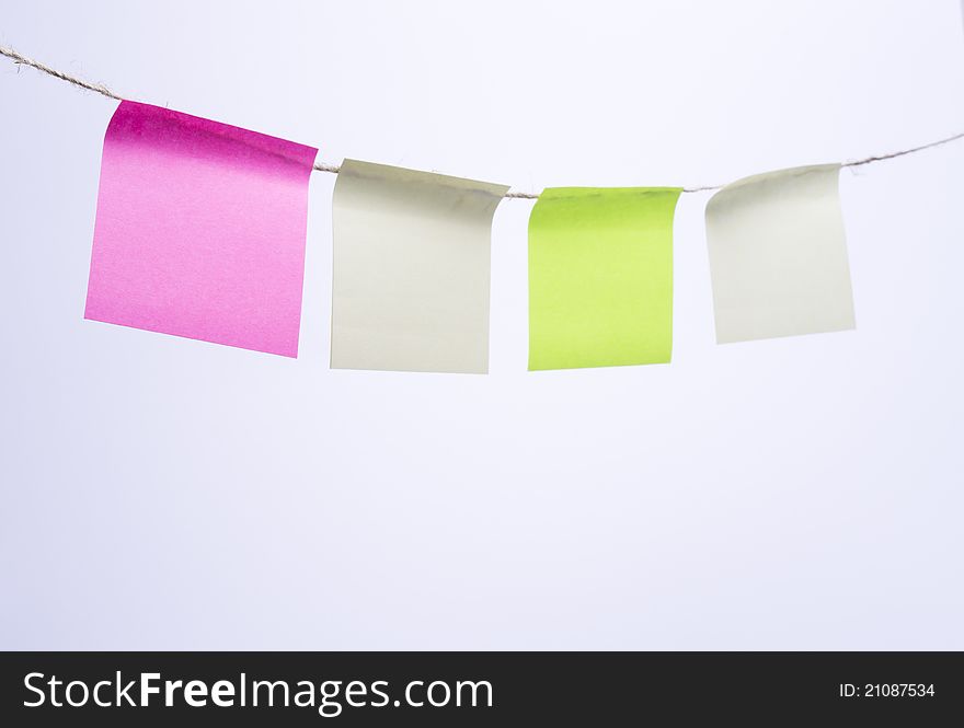 Multi-colored Post-it note paper hanging from clothesline. Multi-colored Post-it note paper hanging from clothesline