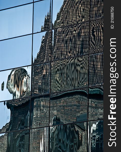 Reflections of old architecture in a glass wall of a modern building. Reflections of old architecture in a glass wall of a modern building