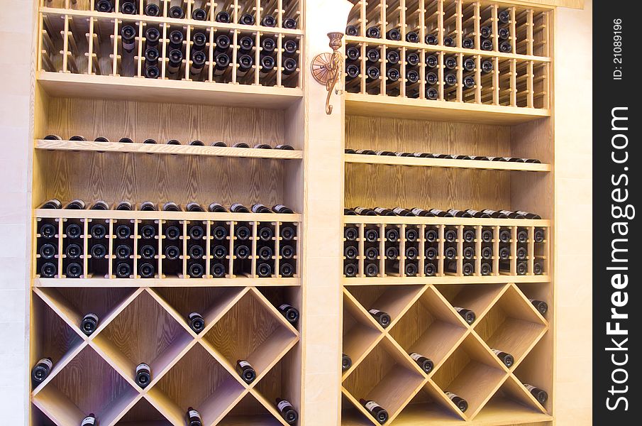 Snapshot of the wine cellar. The bottles on wooden shelves.