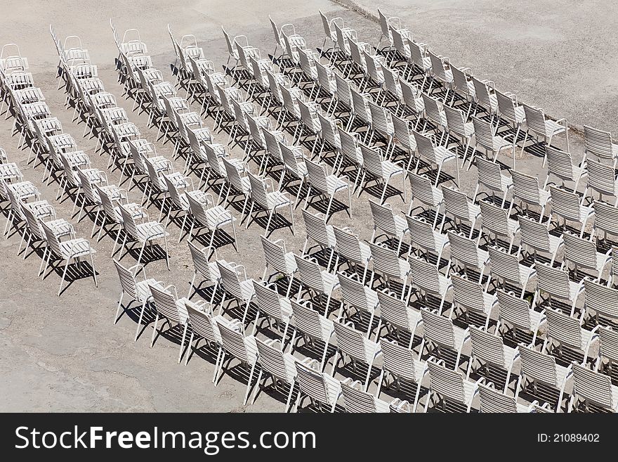 White plastic chairs set for an outdoor event.