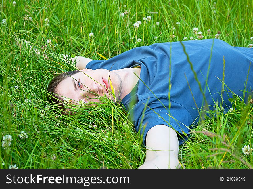 Young man lying on the green grass. Young man lying on the green grass