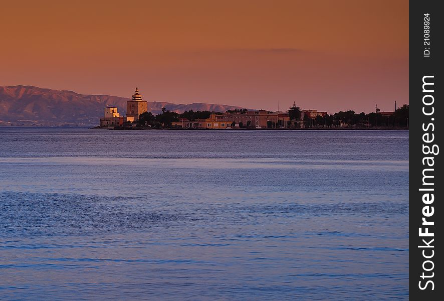 Nice sunset in harbor of Messina. Ancient montorsoli's lighthouse signals the right way to ships passing through the Strait of Messina. Nice sunset in harbor of Messina. Ancient montorsoli's lighthouse signals the right way to ships passing through the Strait of Messina