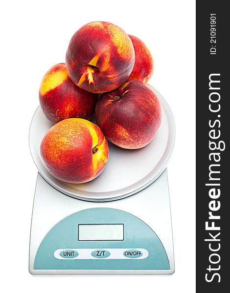 Peaches on the scales on a white background