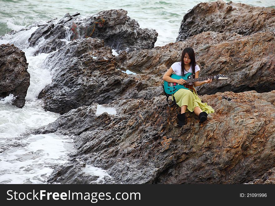 Beautiful Asian Woman With A Guitar On Beach