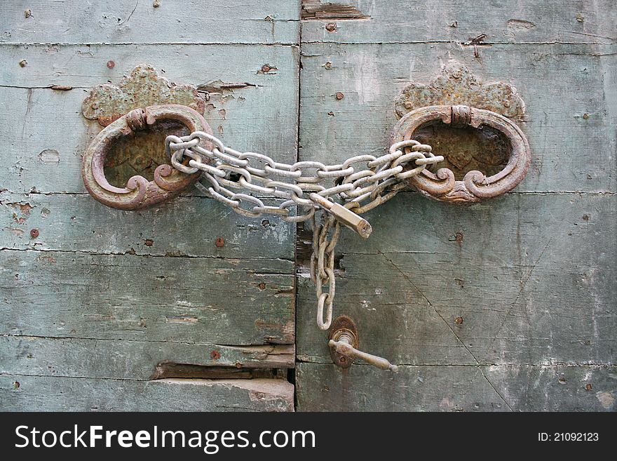 Detail of an old doorway with handles chain and padlock