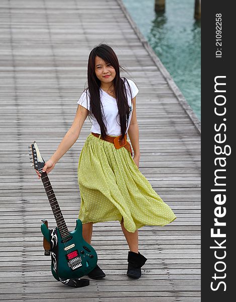 Young pretty woman with guitar on wooden bridge. Young pretty woman with guitar on wooden bridge