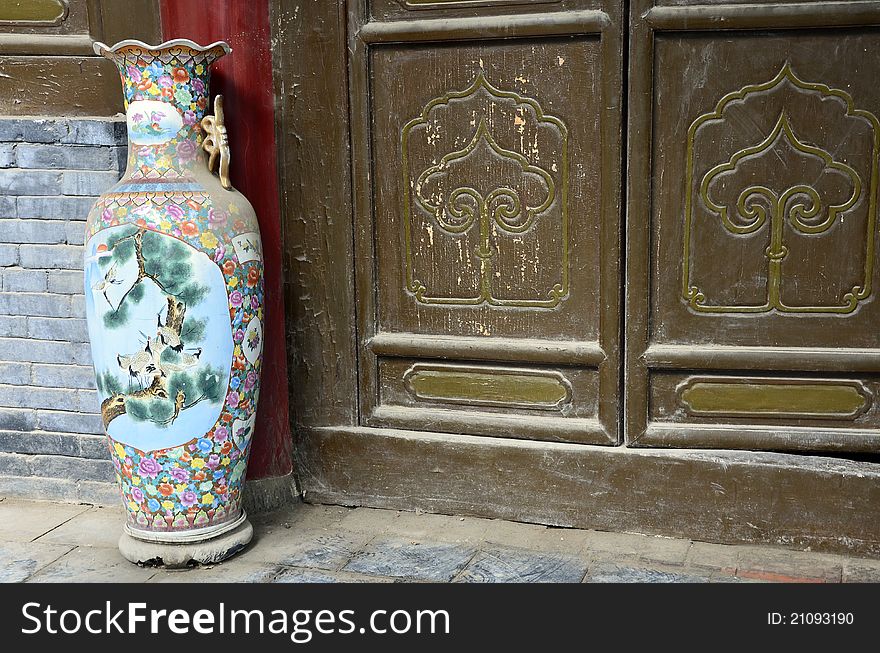 Old Chinese vase near wooden gates. Old Chinese vase near wooden gates