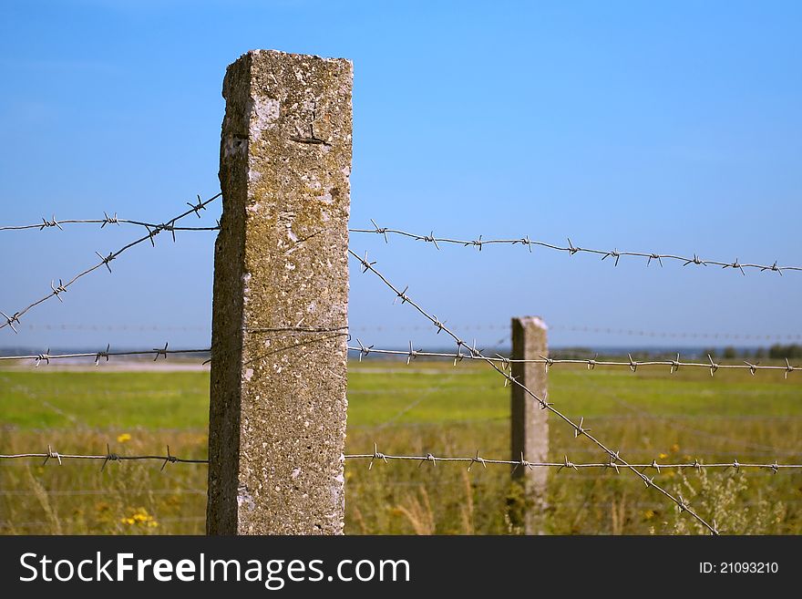 Forbidden zone with a concrete fence and barbed wire. Forbidden zone with a concrete fence and barbed wire