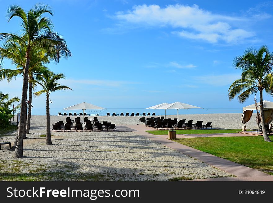Beach chairs and umbrellas prepared and ready for the vacationers. Beach chairs and umbrellas prepared and ready for the vacationers