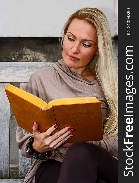 Woman sitting on a bench reading. Woman sitting on a bench reading.