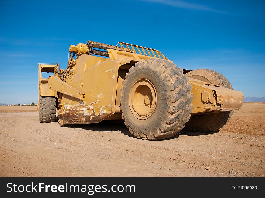 Profile of a Large Earth Mover Parked on a Dirt Lot. Profile of a Large Earth Mover Parked on a Dirt Lot