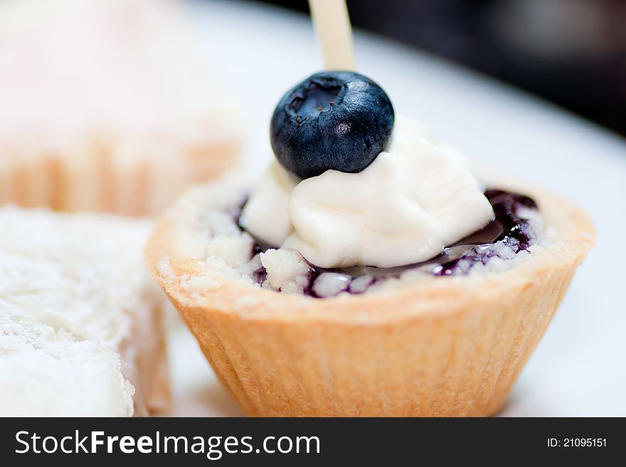 Piece of blueberry cheese cake on white dish