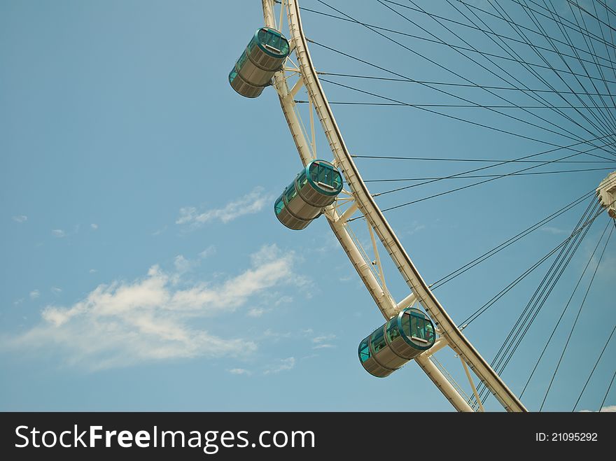 Closeup shot of Ferris wheel and its carriages against a blue sky background. Closeup shot of Ferris wheel and its carriages against a blue sky background.