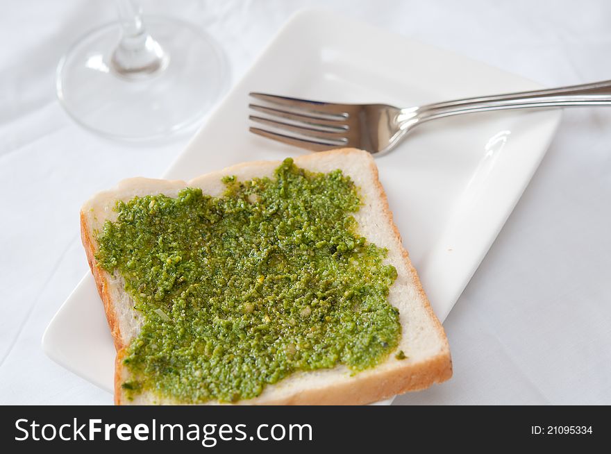 Delicious pesto toast on white plate in Italian restaurant.