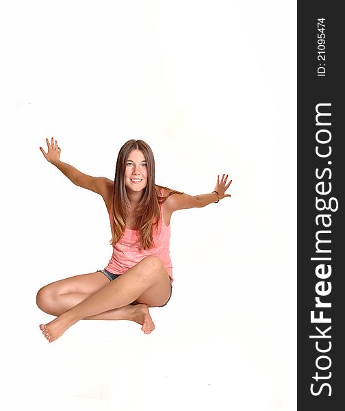 A teenager, sitting on the floor in the studio, is exited and having fun in front of the camera, in bare feet for white background. A teenager, sitting on the floor in the studio, is exited and having fun in front of the camera, in bare feet for white background.