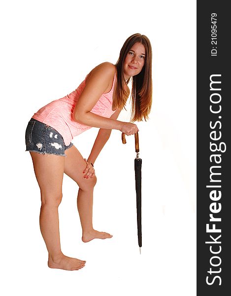 An teenager in jeans shorts and a pink top with an mans umbrella in her hand, standing bare feet in the studio, for white background. An teenager in jeans shorts and a pink top with an mans umbrella in her hand, standing bare feet in the studio, for white background.