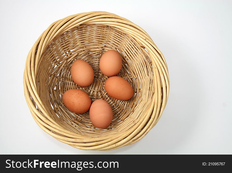 Five brown hens eggs in light brown wicker basket, on white background. Five brown hens eggs in light brown wicker basket, on white background.