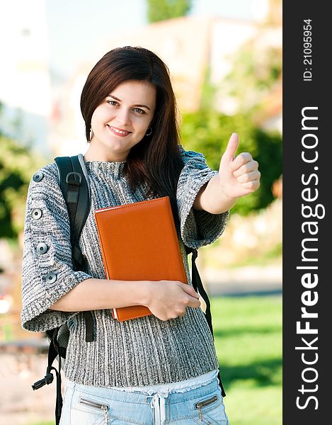 Portrait of a young female student with books at the campus