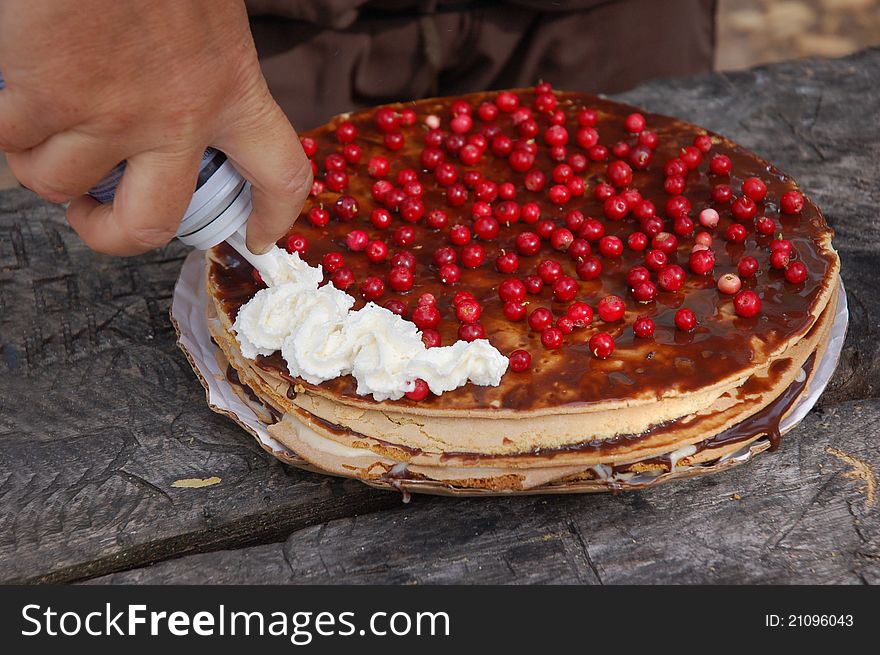 Cake with cranberry, chocolate, sugar and cream by culinary syringe