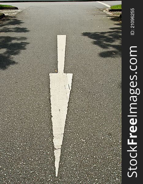 An empty street with a downward pointing white arrow. An empty street with a downward pointing white arrow