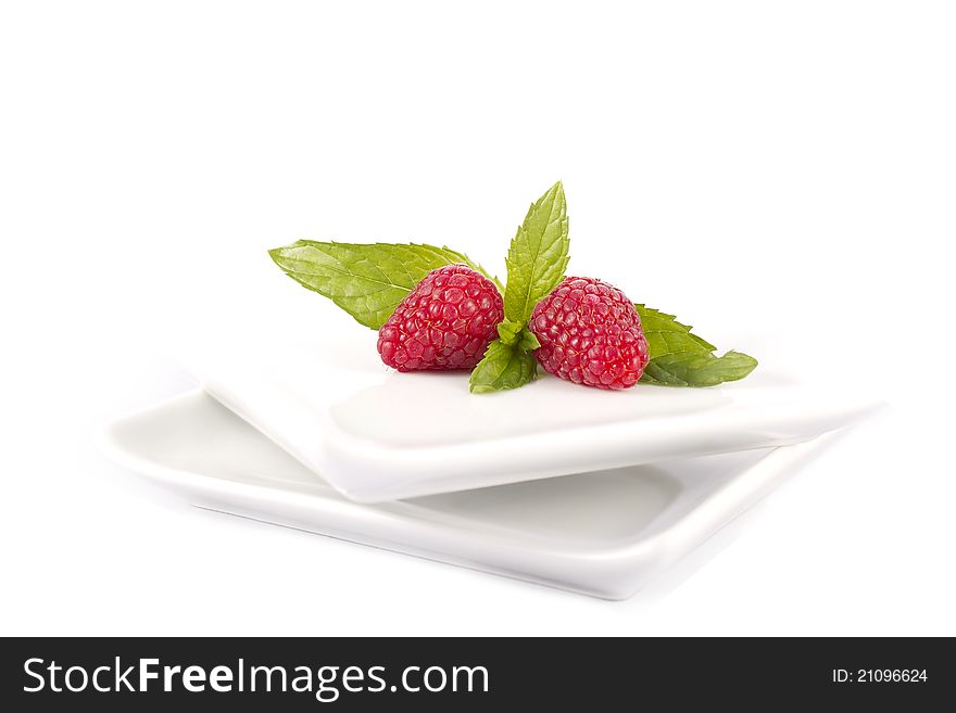 Raspberries in a white plate on a white background. Raspberries in a white plate on a white background