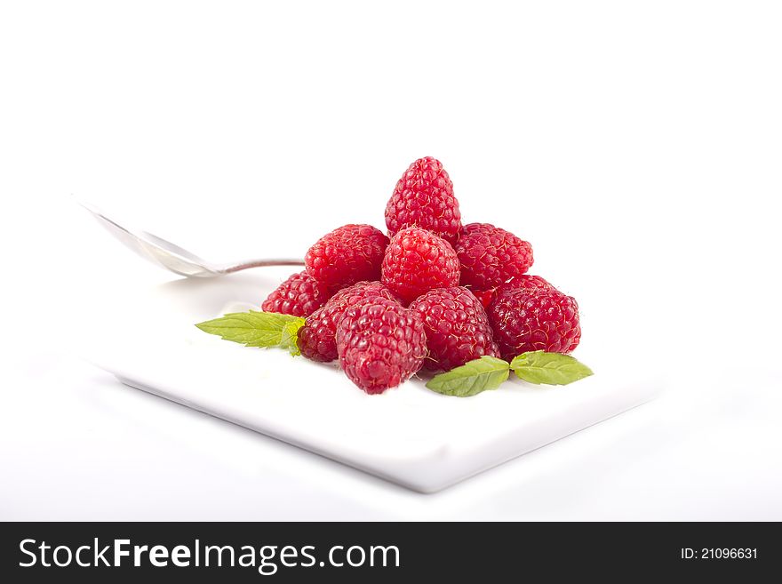 Raspberries in a white plate on a white background. Raspberries in a white plate on a white background