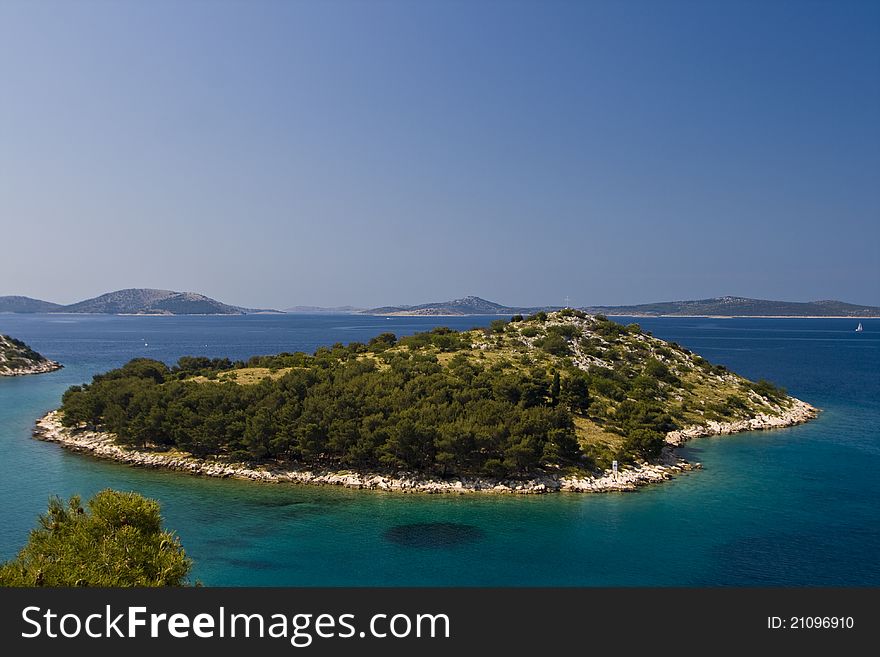 Green island in the aquamarine sea in Tribunj