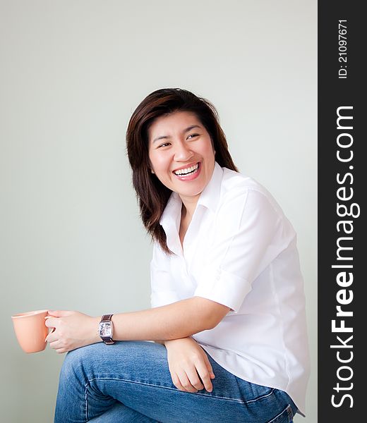 Smiling young asian woman holding a cup