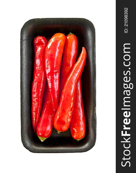 Red chili on black tray isolated on white background